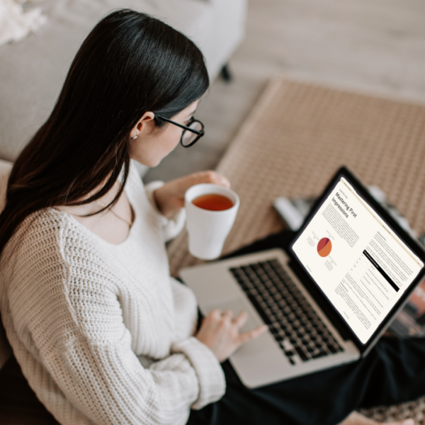 A woman drinking tea and reading ebook on social etiquette From shy to shine