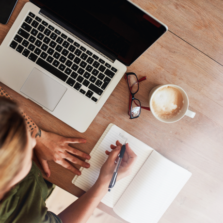 woman studying an etiquette online course by Manners with Kristina, taking notes,